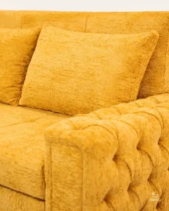 تصویر کلوزآپ دسته چستر با لمسه‌دوزی شیک و طراحی کلاسیک روی مبل تخت خوابشو ریلی دو نفره